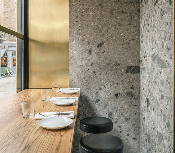 Contemporary bar table with stools and Ceppo di Gre stone walls.