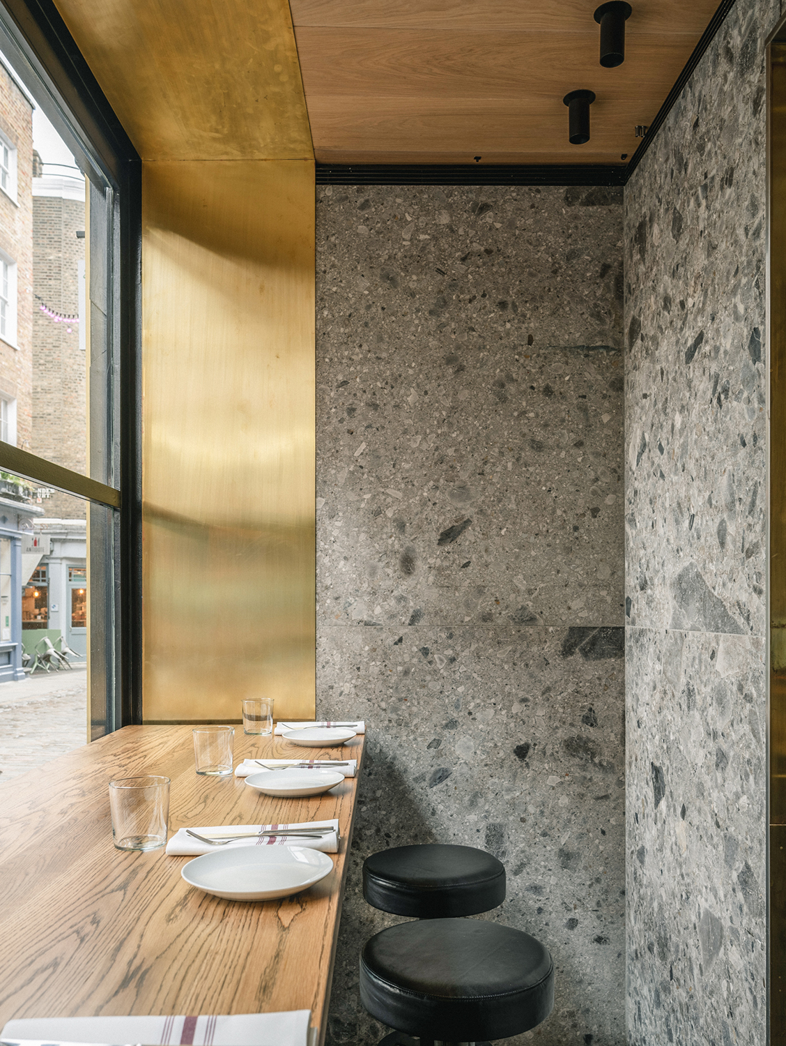 Contemporary bar table with stools and Ceppo di Gre stone walls.