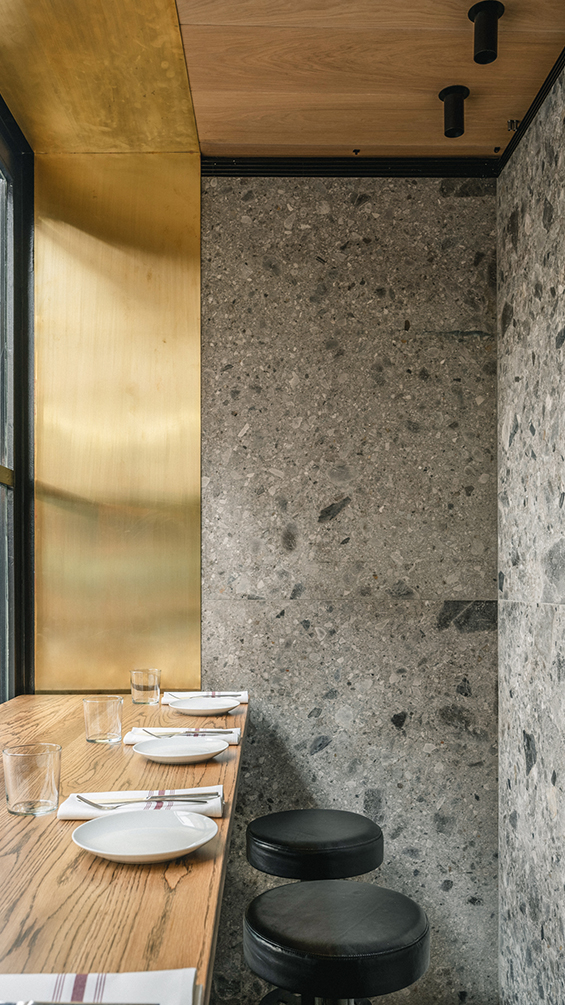 Contemporary bar table with stools and Ceppo di Gre stone walls.