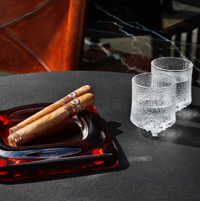 Cigars on a luxury glass cigar ashtray.