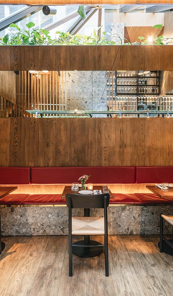 Contemporary gastro bar interior design with cast-iron shelving and open kitchen.