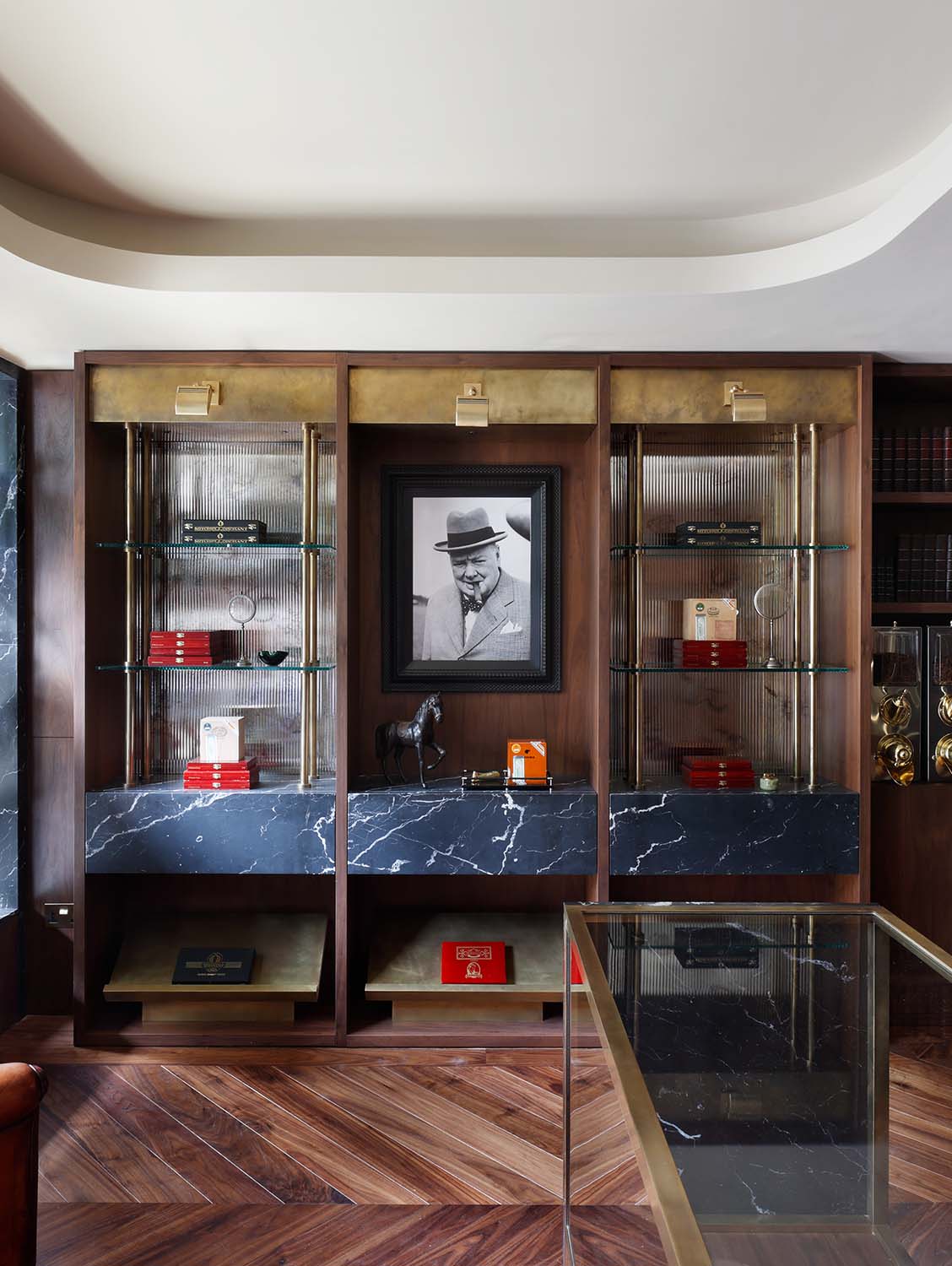 Luxury cigar lounge bespoke timber and glass shelving unit with Winston Churchill photograph.
