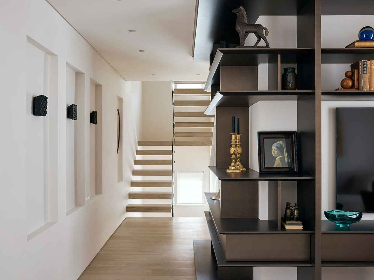 Contemporary small hallway with bespoke cabinetry and wide staircase with single glazed handle.