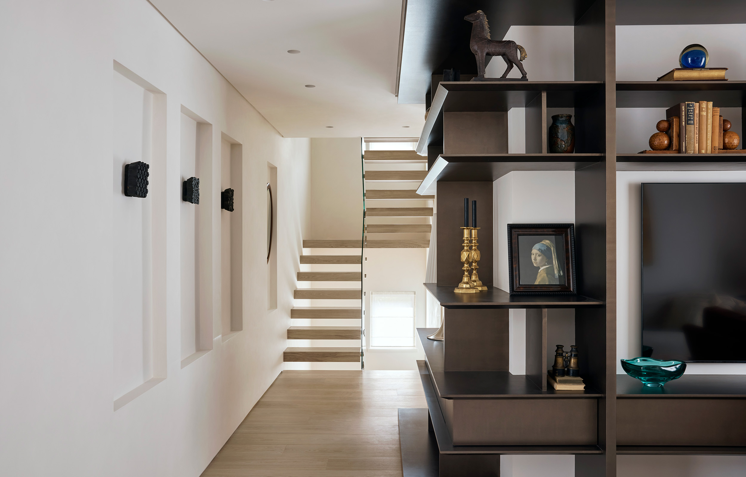 Contemporary small hallway with bespoke cabinetry and wide staircase with single glazed handle.