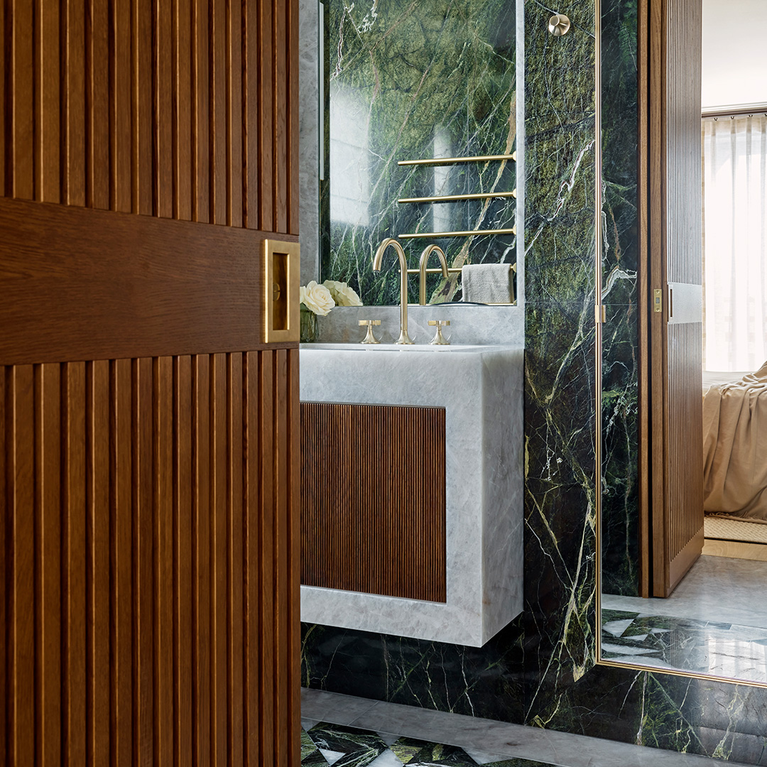 Luxury en suite bathroom with brass and marble features.