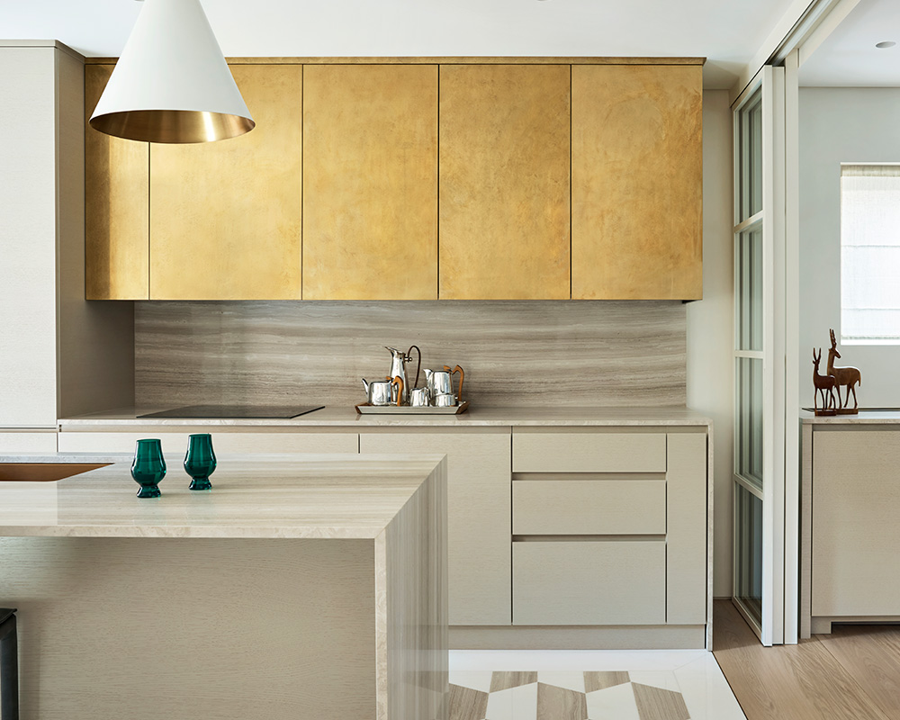 Bespoke open plan kitchen layout with kitchen island and marble and brass finishes.