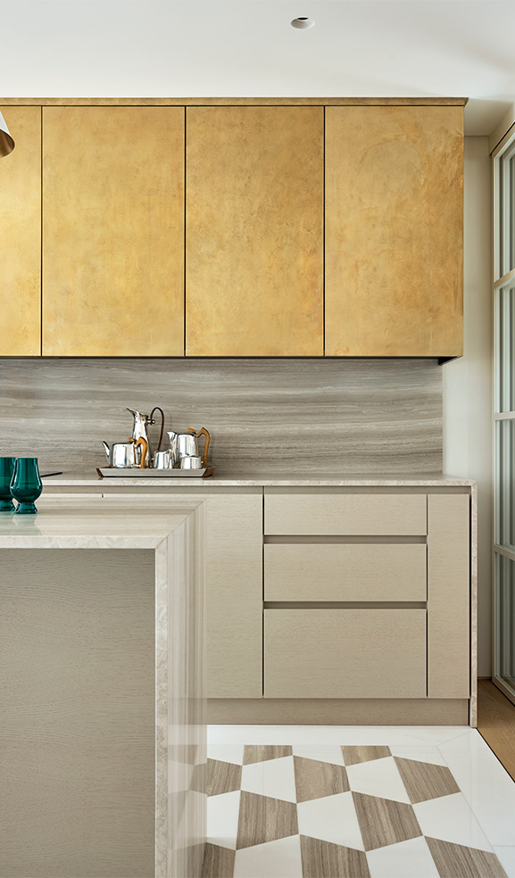 Bespoke open plan kitchen layout with kitchen island and marble and brass finishes.