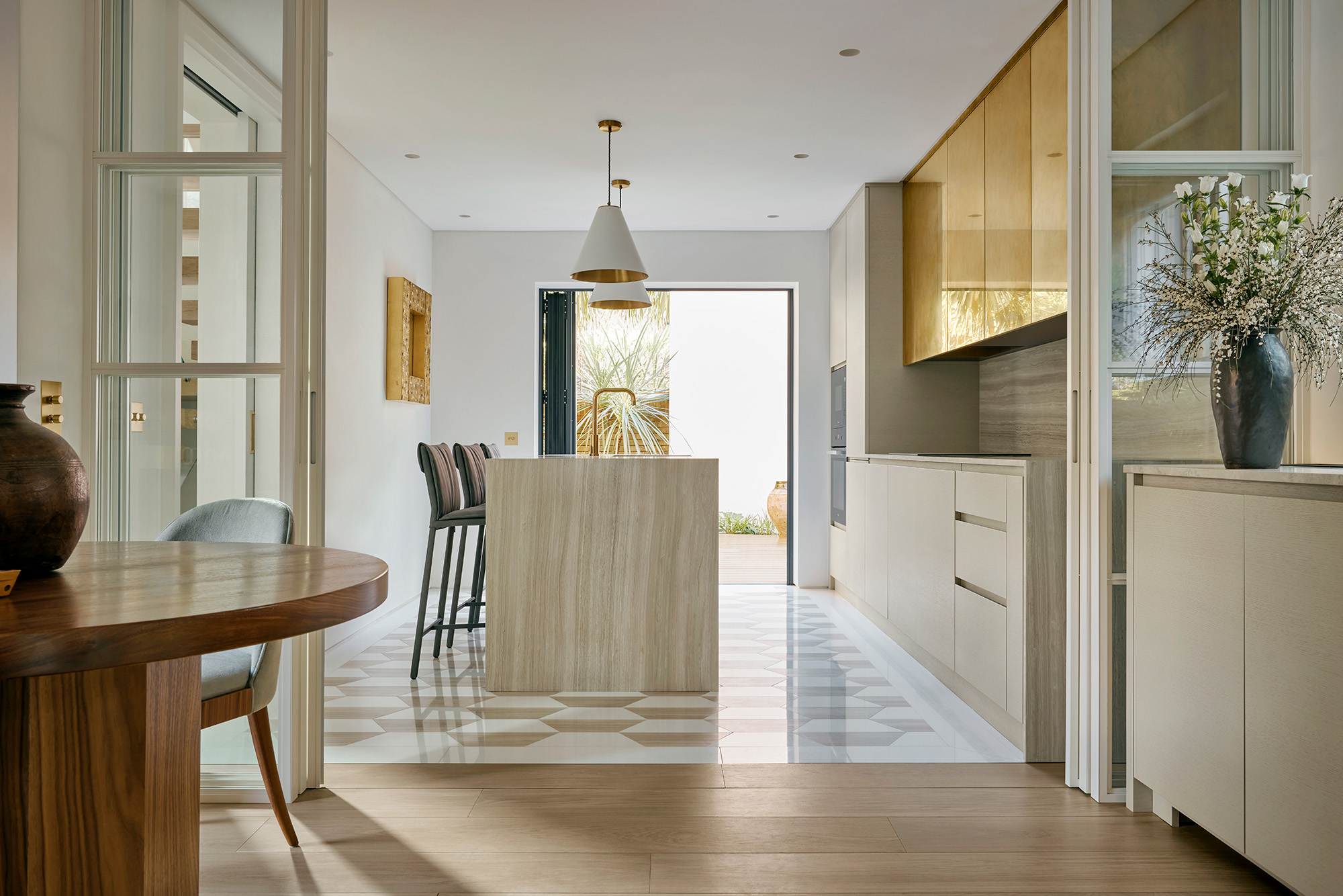 Bespoke open plan kitchen layout with kitchen island and marble and brass finishes.