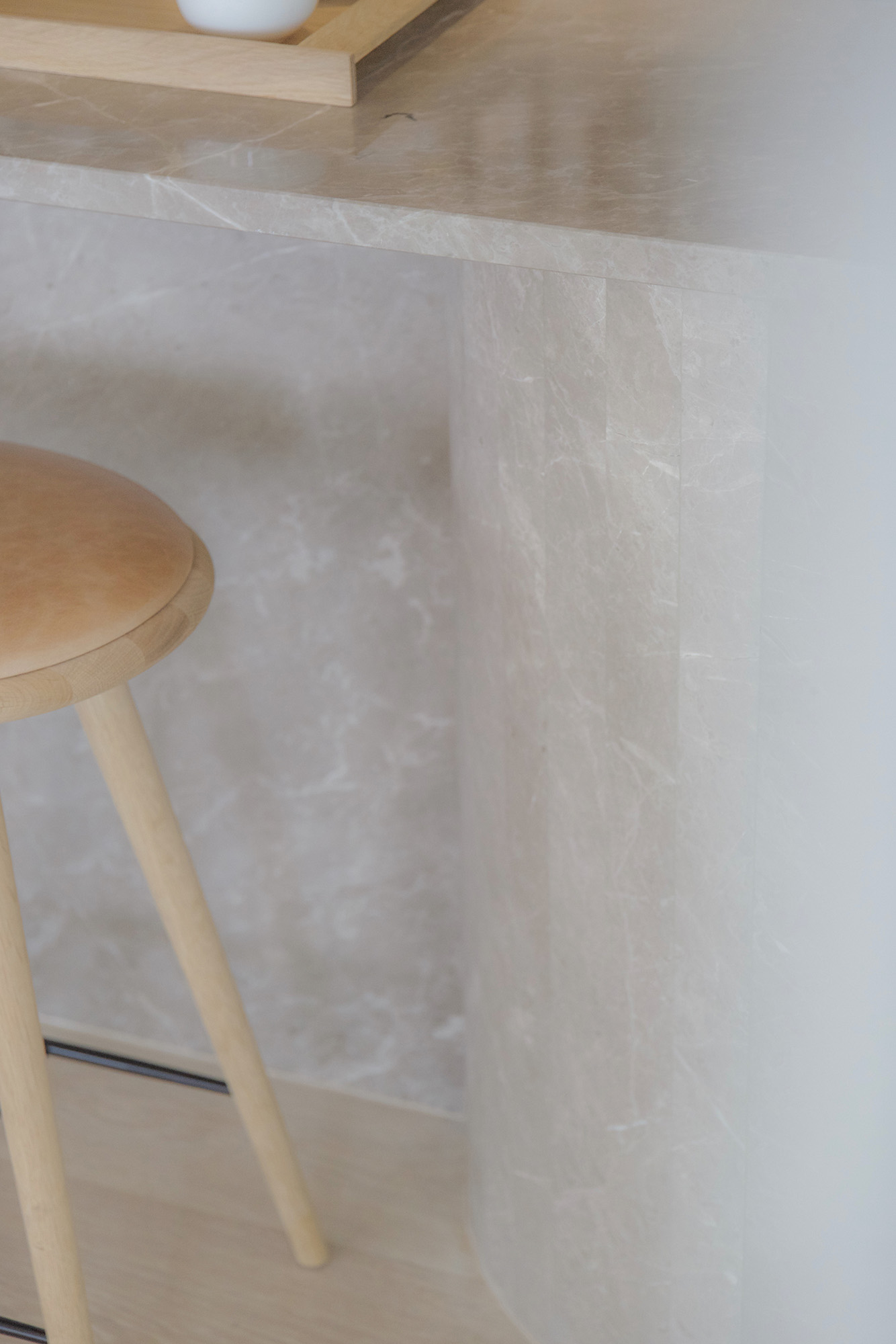 Limestone counter and wooden stool.